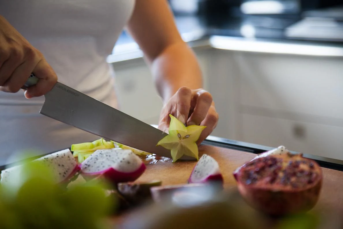 a person cutting a fruit aboard LADY L Yacht for Charter