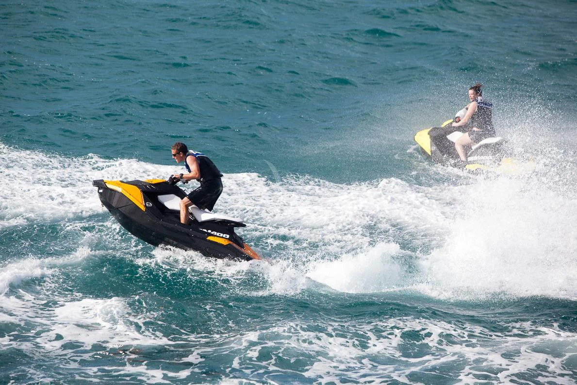 a couple of men on a jet ski in the ocean aboard LADY L Yacht for Charter