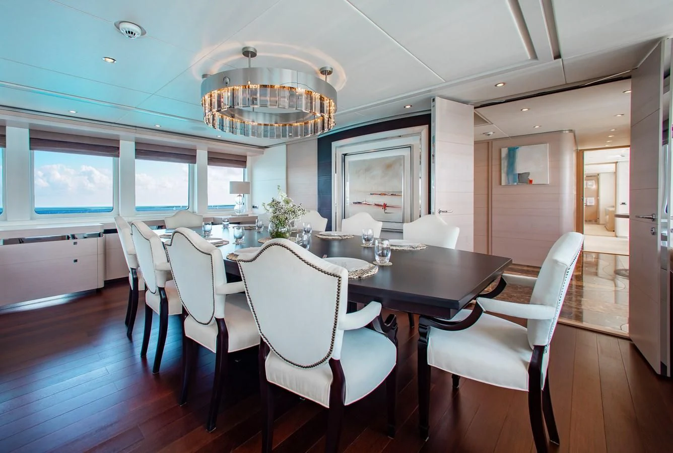 a dining room with white chairs aboard LADY L Yacht for Charter
