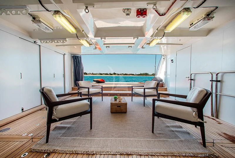 a pool table and chairs in a room with a pool and a deck aboard LADY L Yacht for Charter