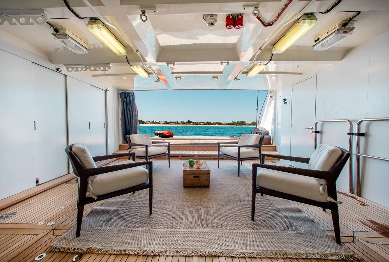 a pool table and chairs in a room with a pool and a deck aboard LADY L Yacht for Charter