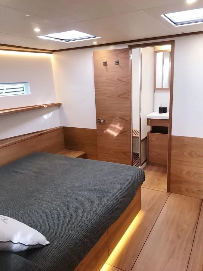 a bedroom with a bed and desk aboard ONE SHOT Yacht for Sale