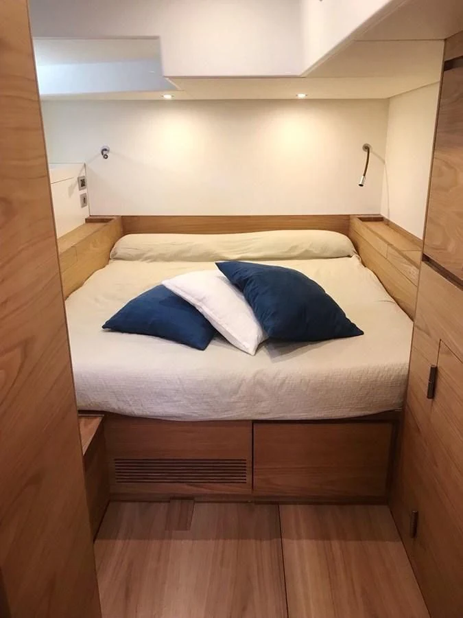 a bed with blue and white pillows aboard ONE SHOT Yacht for Sale