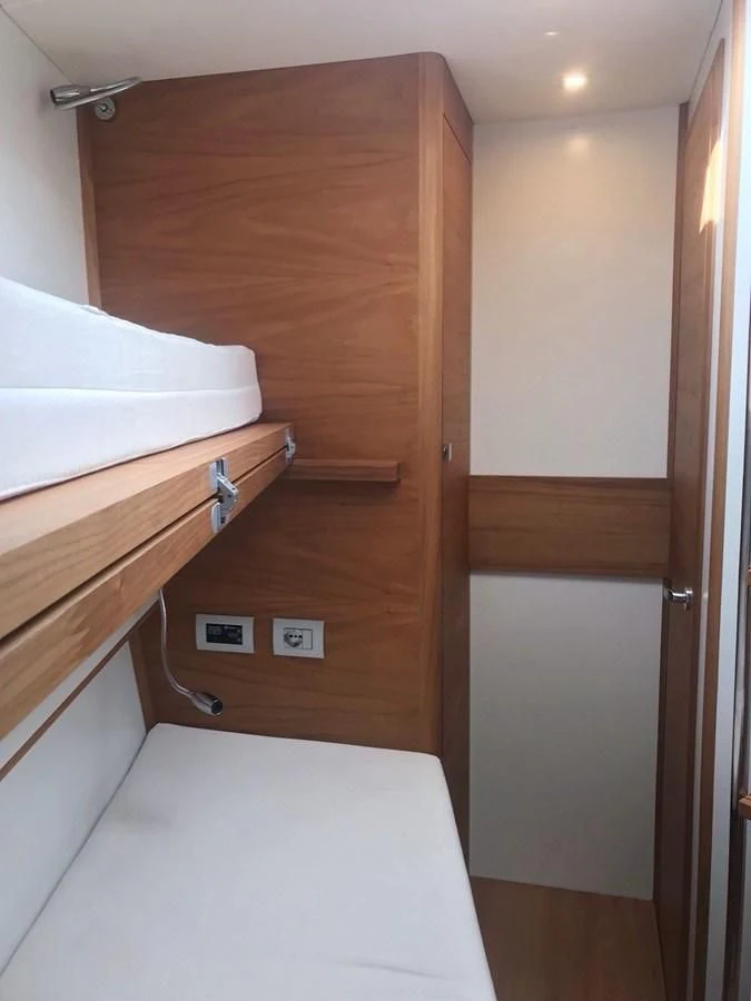 a bed with a wooden headboard aboard ONE SHOT Yacht for Sale