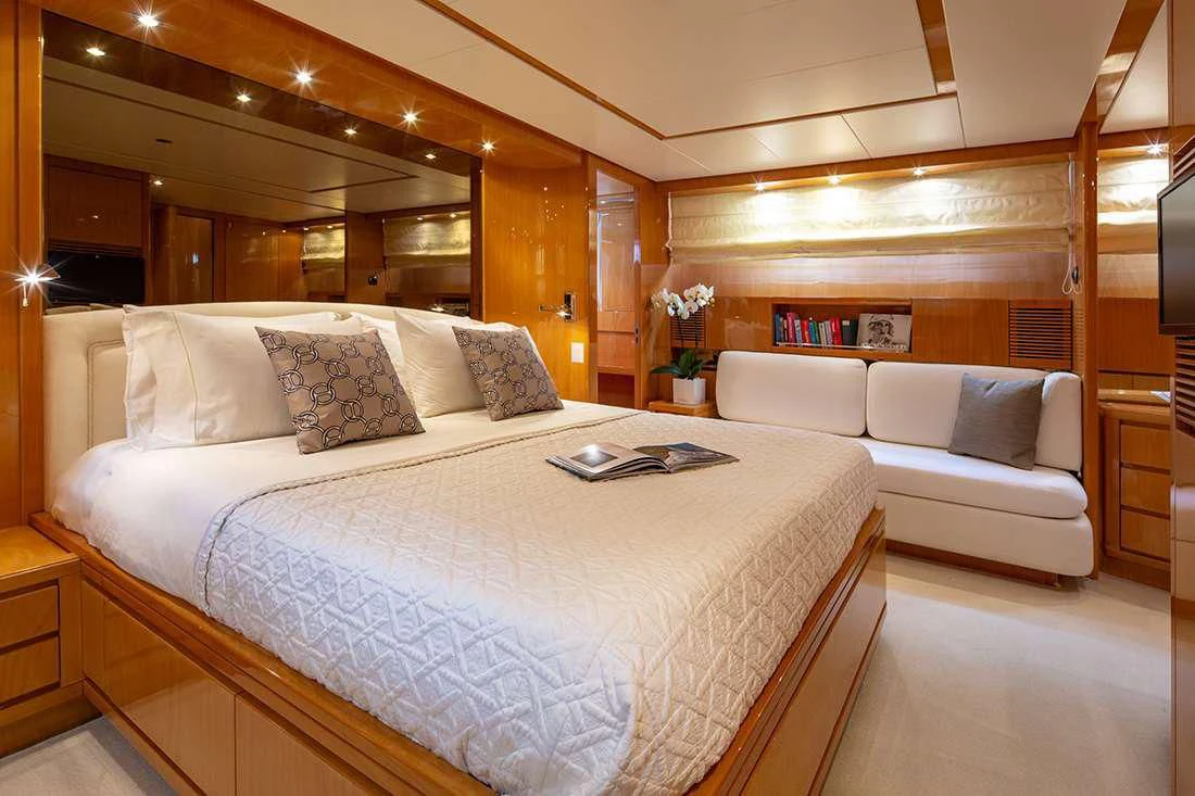 a bed with a white couch aboard THE BIRD Yacht for Charter