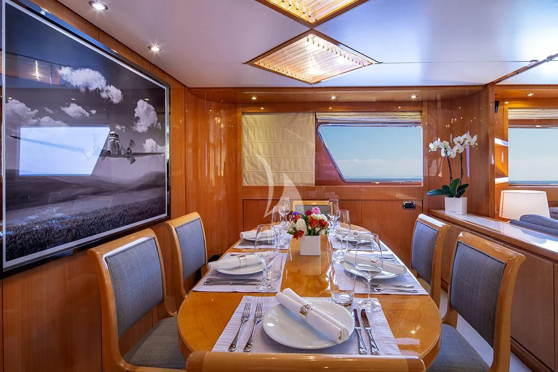 a dining table with plates and chairs aboard THE BIRD Yacht for Charter
