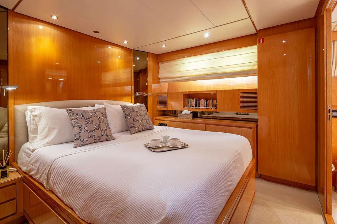 a bed with white sheets and pillows aboard THE BIRD Yacht for Charter