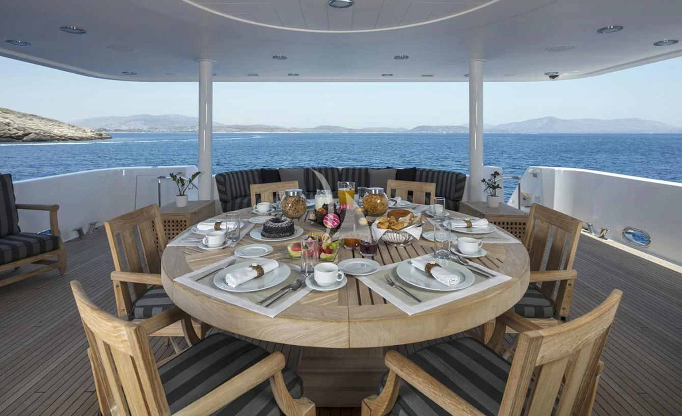 a table set for a meal on a deck overlooking the ocean aboard ENDLESS SUMMER Yacht for Sale