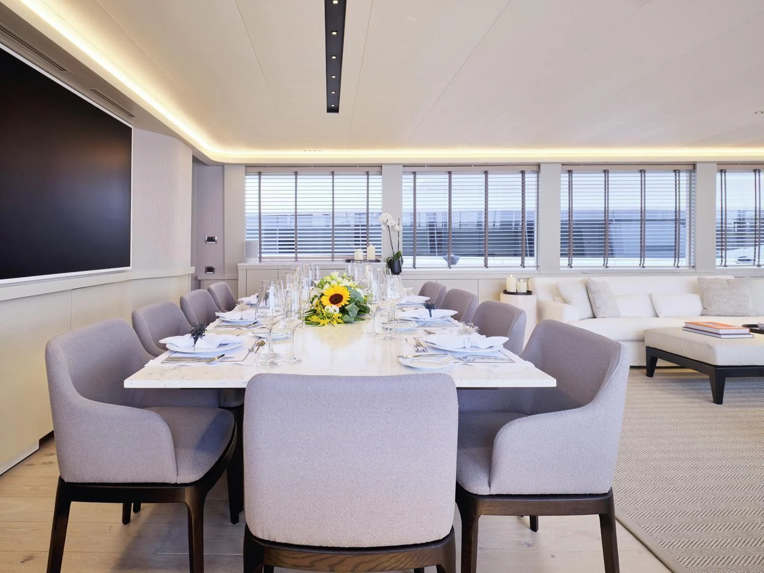 a large white table with chairs and a large screen on the wall aboard ENDLESS SUMMER Yacht for Sale