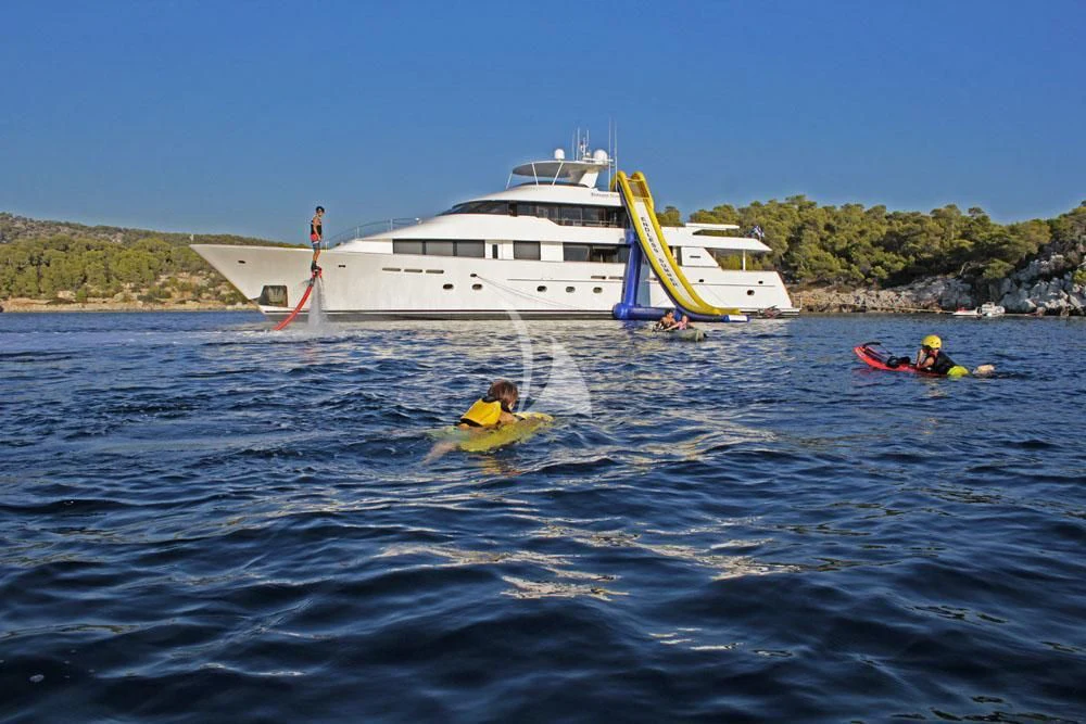 a group of people in a body of water with a boat in the background aboard ENDLESS SUMMER Yacht for Sale