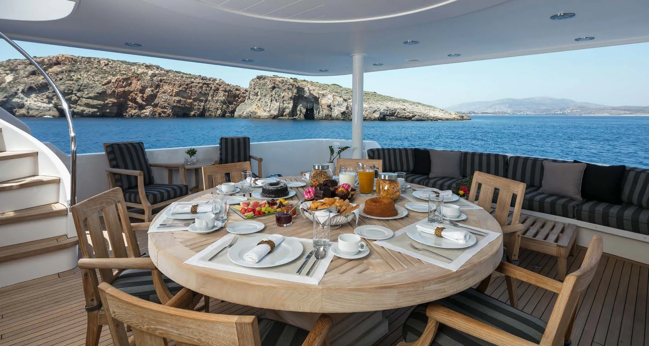 a table set for a meal on a balcony overlooking the ocean aboard ENDLESS SUMMER Yacht for Sale