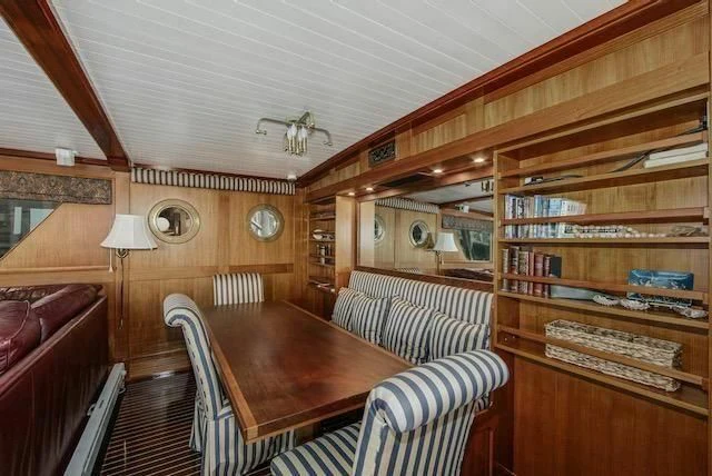 a living room with a wood table aboard LADY FAYE Yacht for Sale