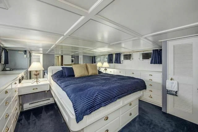 a bedroom with a bed and a lamp aboard LADY FAYE Yacht for Sale