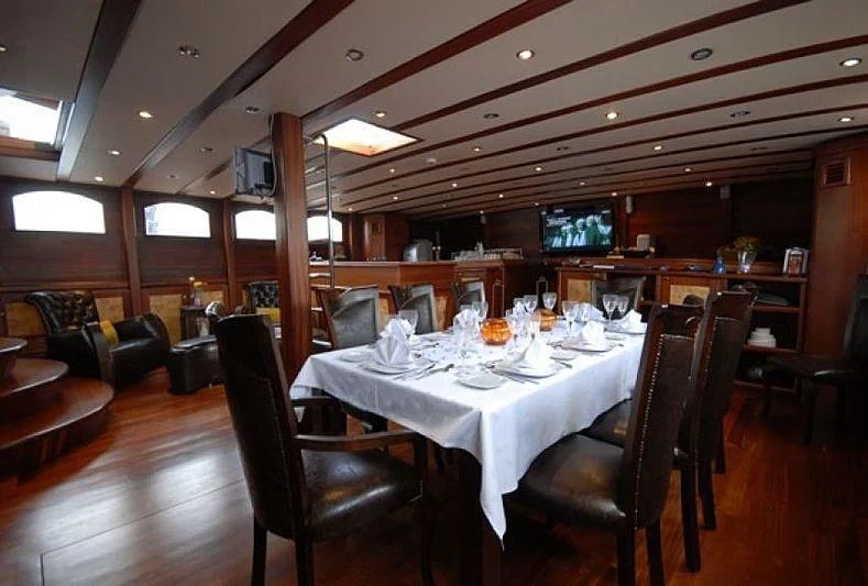 a large room with a table and chairs aboard PHELAN GOOD Yacht for Sale