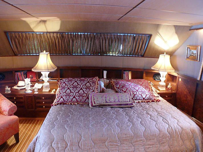 a bed with a purple comforter aboard C SIDE Yacht for Sale