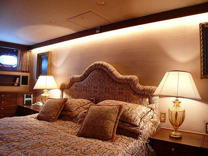 a bed with a couch and a lamp in a room aboard C SIDE Yacht for Sale