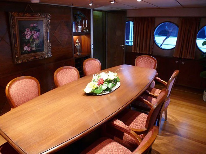 a dining table with chairs and a television on the wall aboard C SIDE Yacht for Sale