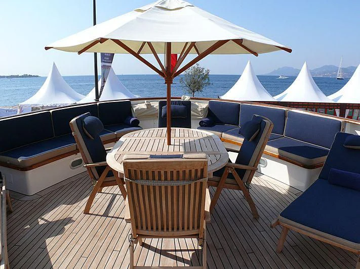 a table and chairs on a deck aboard C SIDE Yacht for Sale