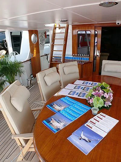 a dining table with a blue tablecloth and chairs aboard C SIDE Yacht for Sale