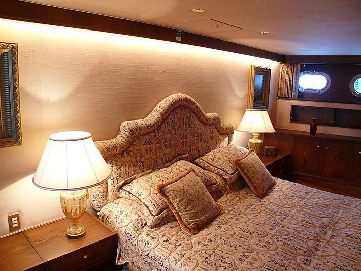a bed with a couch and a television on the wall aboard C SIDE Yacht for Sale