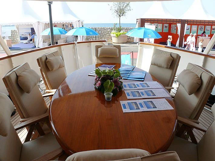 a table with chairs and umbrellas aboard C SIDE Yacht for Sale