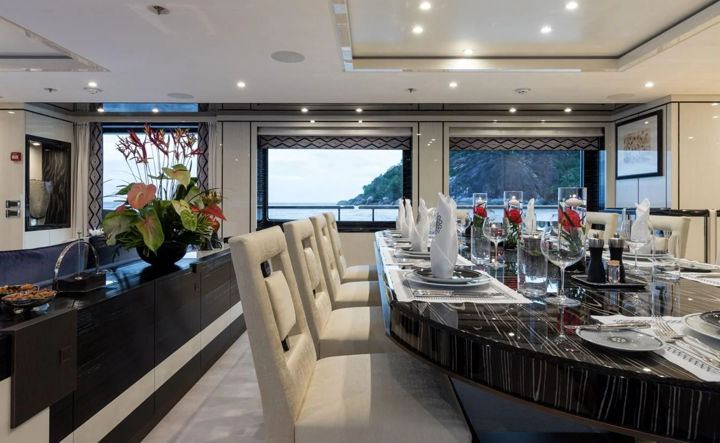 a dining room with a large window aboard AMIGOS Yacht for Charter