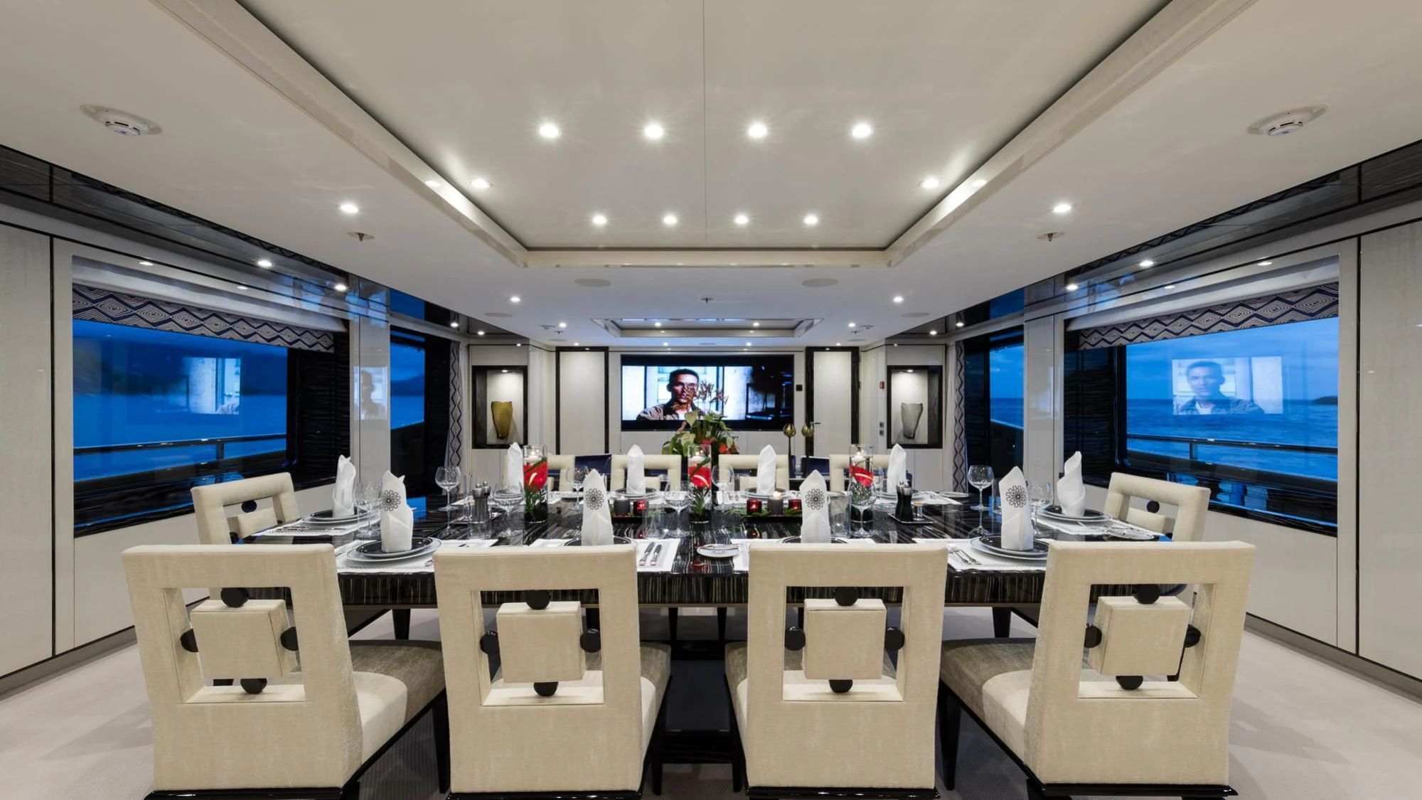 a large room with a table and chairs and a tv aboard AMIGOS Yacht for Charter