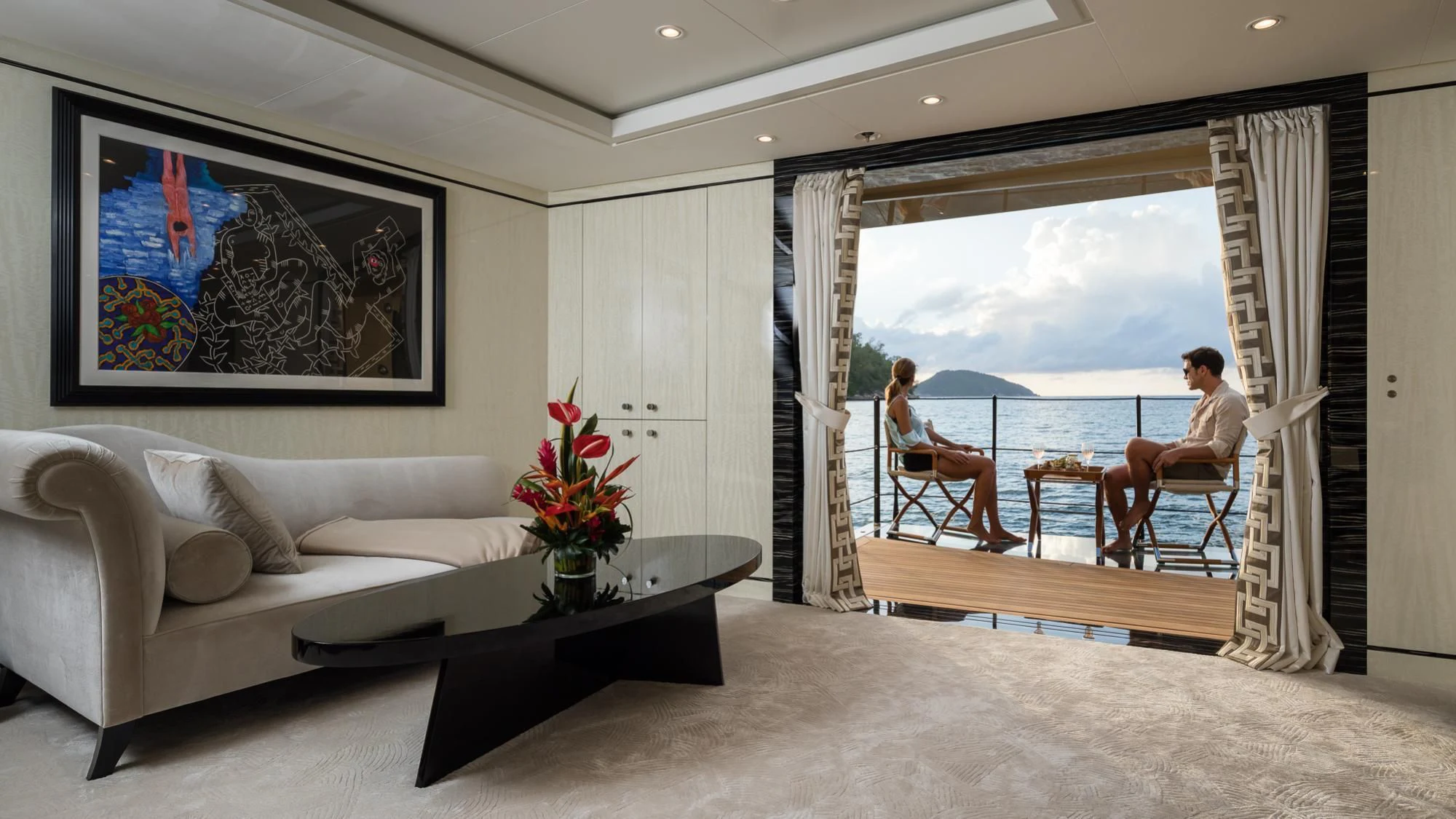 a person sitting at a table in a room with a large window aboard AMIGOS Yacht for Charter