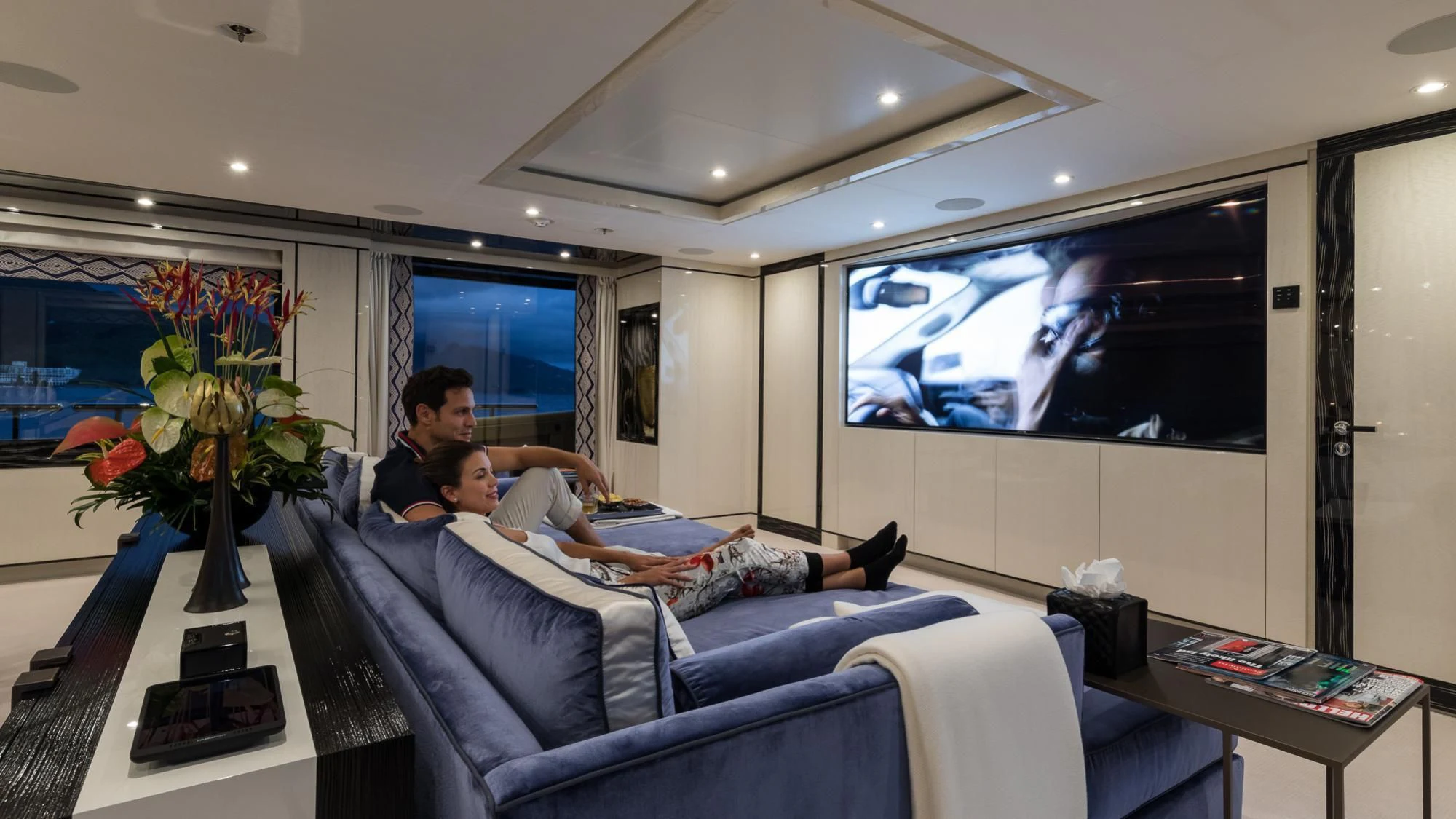 a man sitting on a couch with a woman on the couch aboard AMIGOS Yacht for Charter