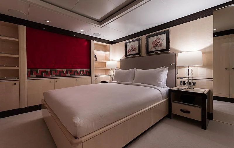 a bedroom with a red wall aboard AMIGOS Yacht for Charter