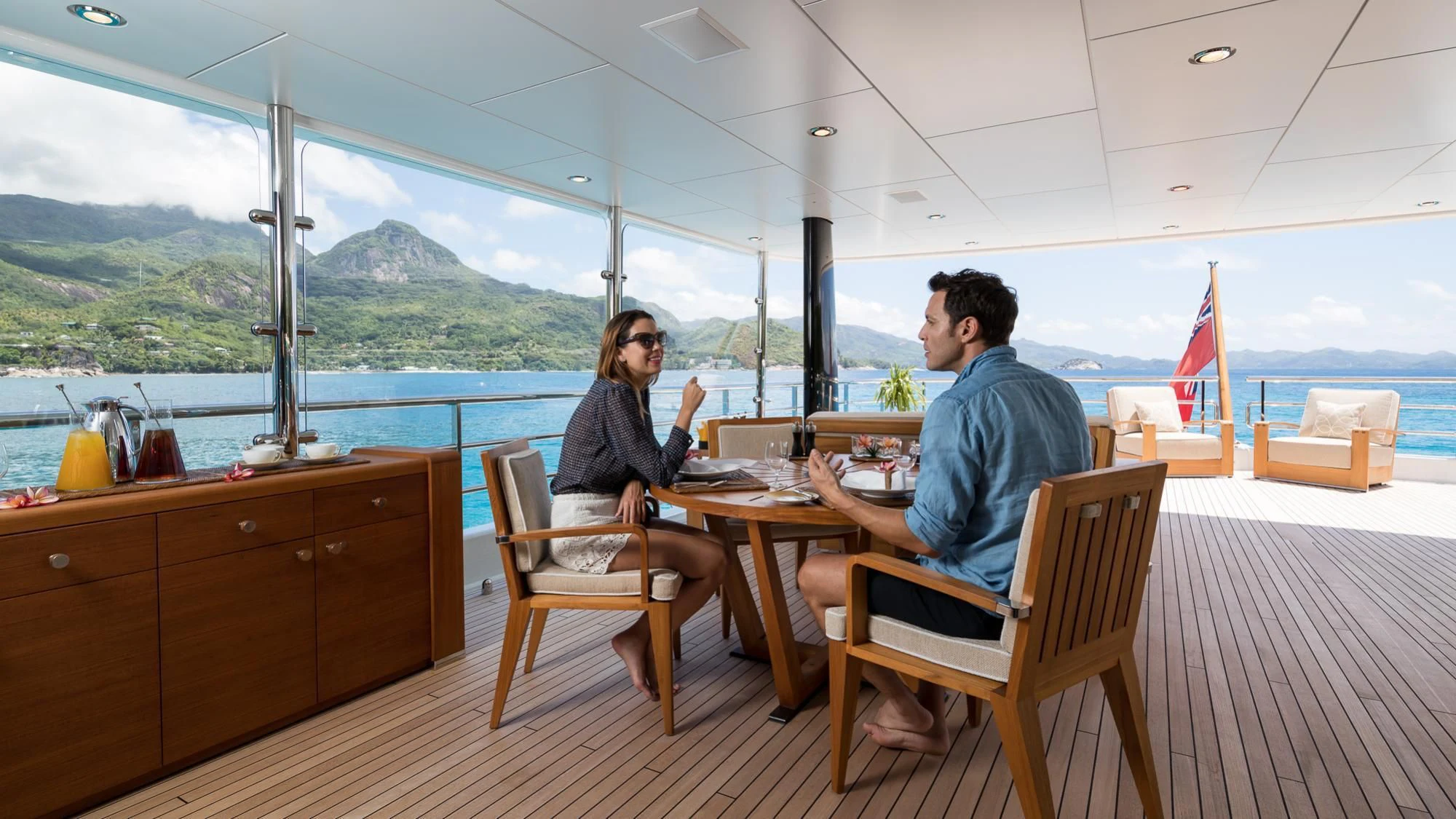 a man and a woman sitting at a table in a restaurant aboard AMIGOS Yacht for Charter