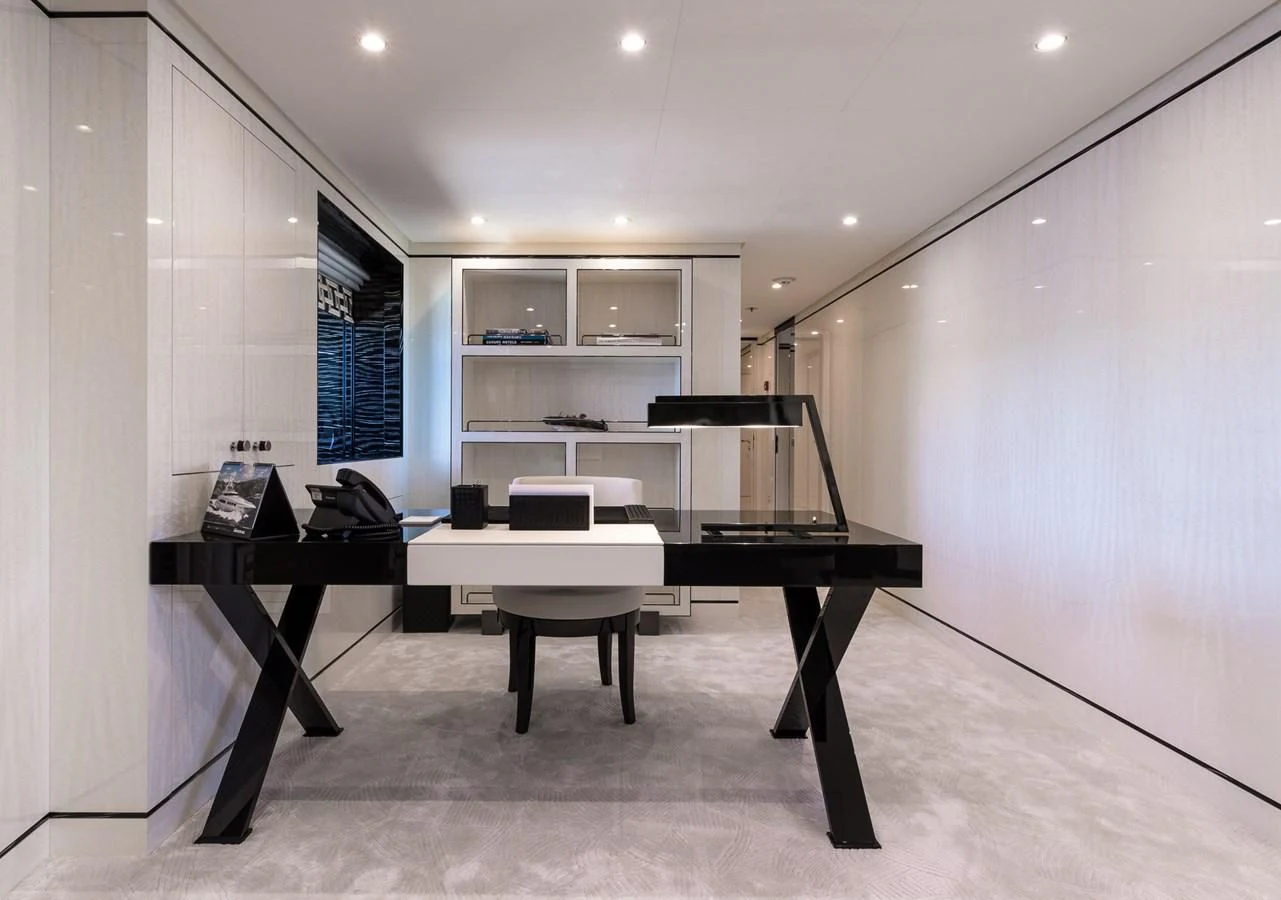 a room with a desk and a shelf with books on it aboard AMIGOS Yacht for Charter