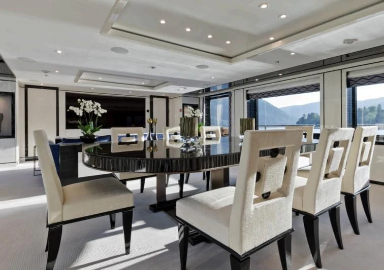 a room with a table chairs and a large window aboard AMIGOS Yacht for Charter