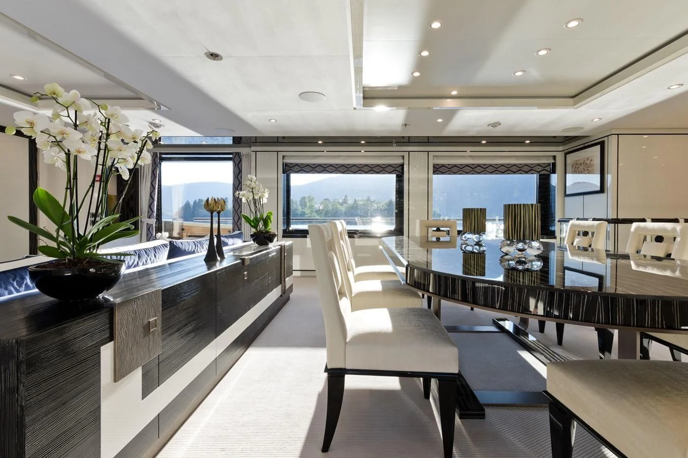 a room with a large window and a desk with a chair and a plant in it aboard AMIGOS Yacht for Charter