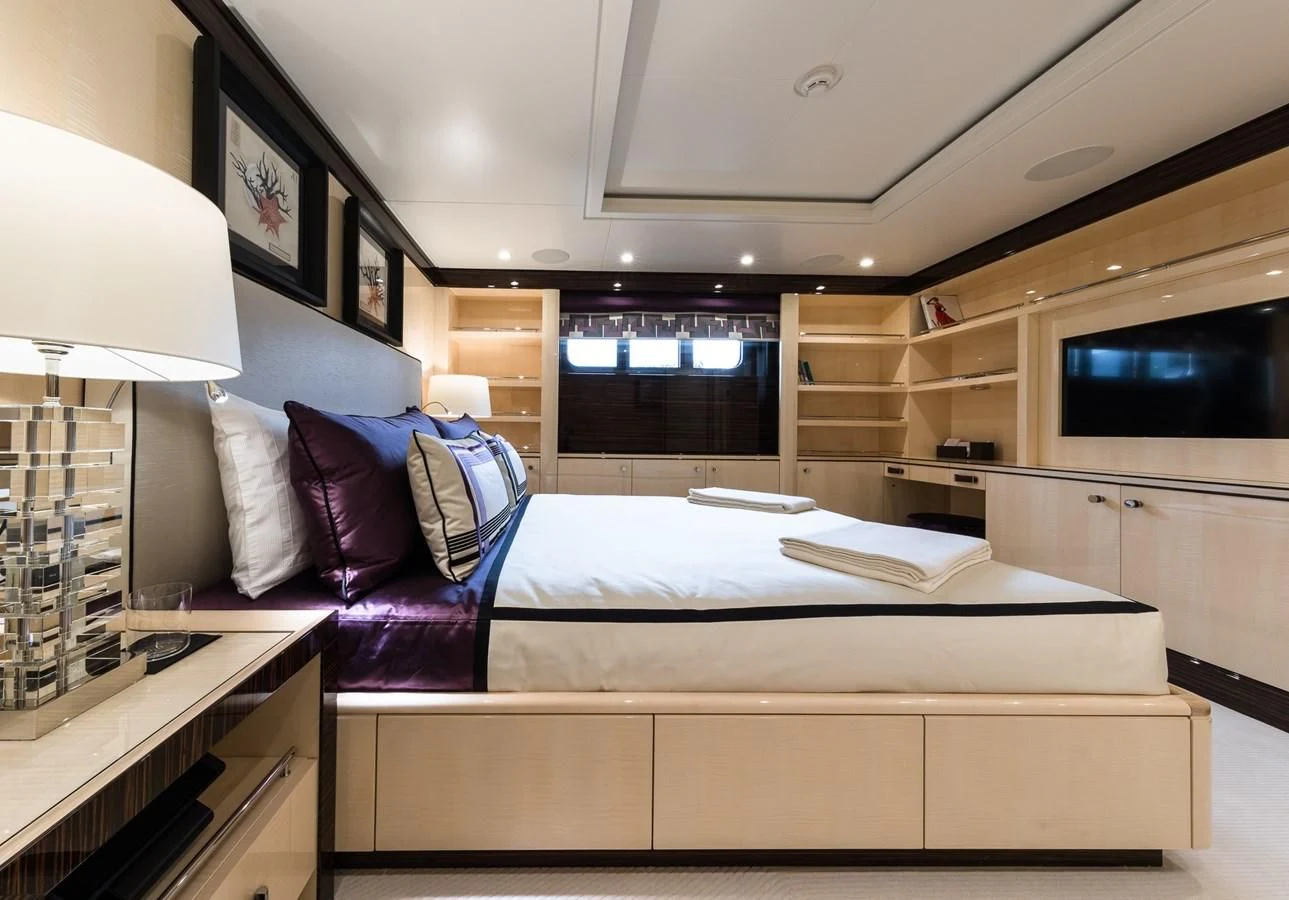 a room with a bed and a tv on the wall aboard AMIGOS Yacht for Charter