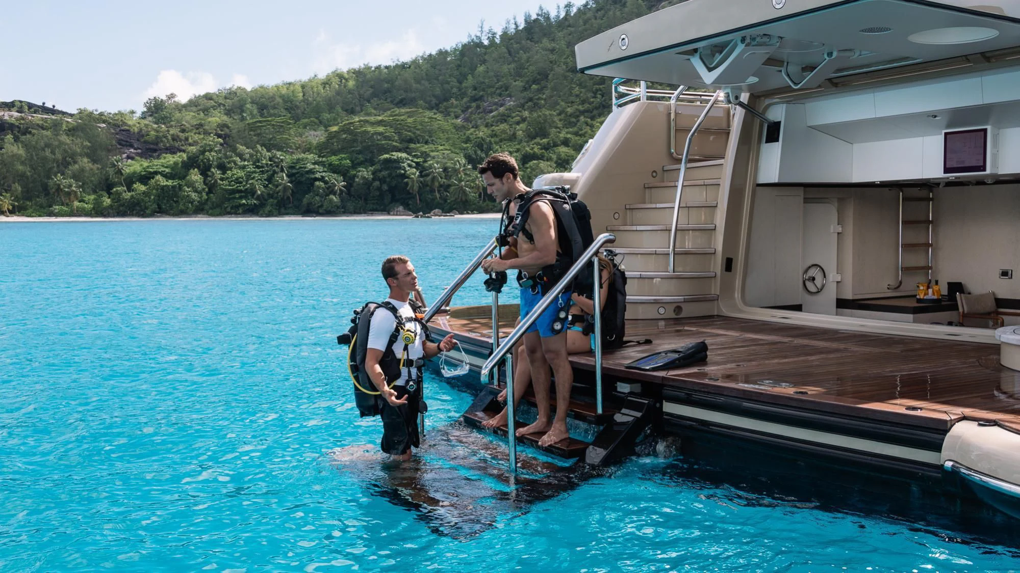 a couple of men standing on a dock with a boat in the water aboard AMIGOS Yacht for Charter