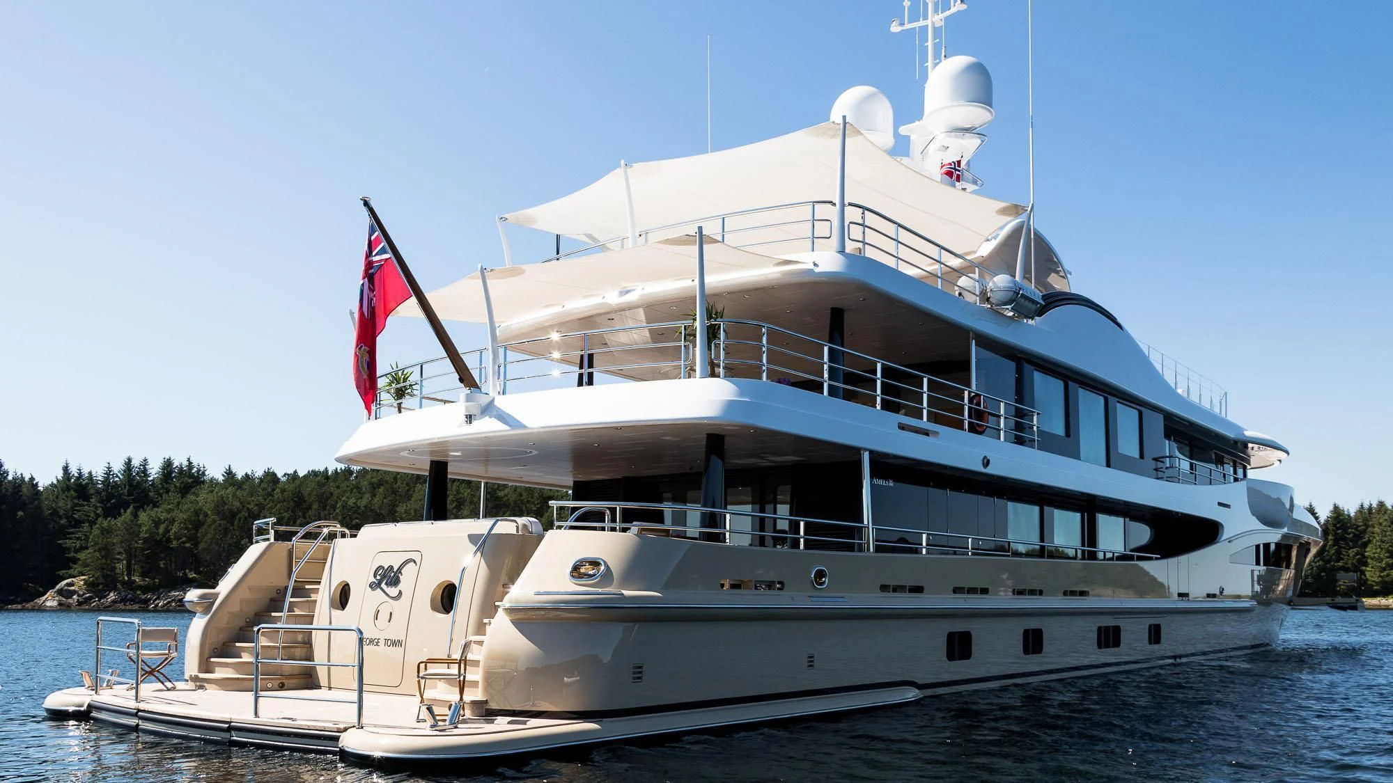 a large white boat with a flag on top aboard AMIGOS Yacht for Charter