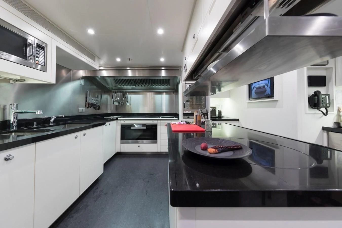 a kitchen with a black countertop aboard AMIGOS Yacht for Charter