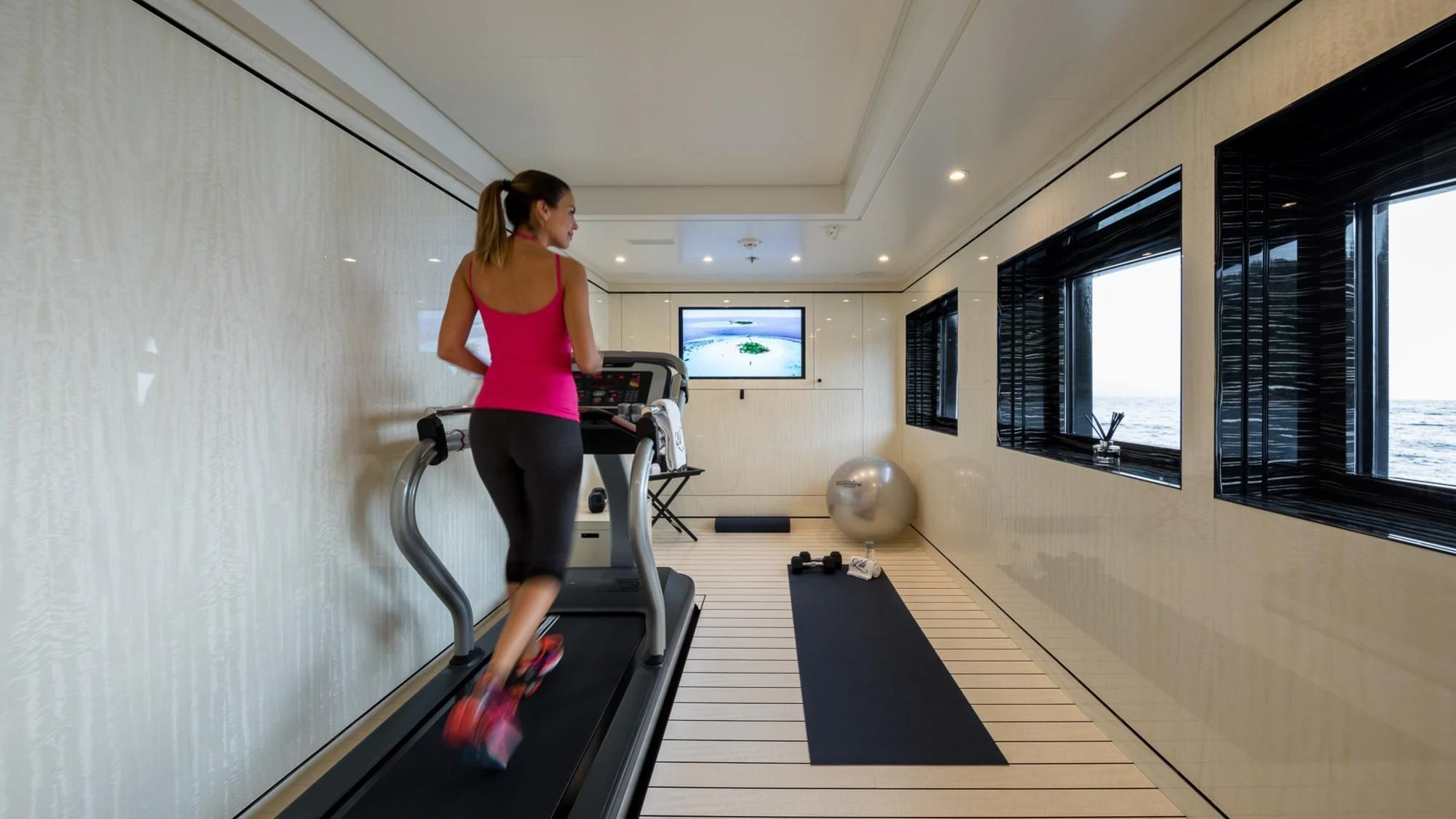a person exercising in a gym aboard AMIGOS Yacht for Charter