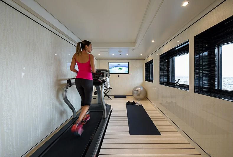 a person running on a treadmill aboard AMIGOS Yacht for Charter