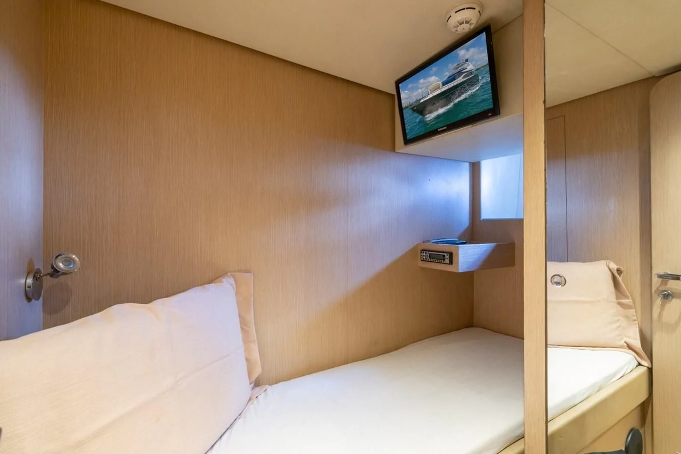 a bed with a television on the wall aboard NAMEDROPPER Yacht for Sale