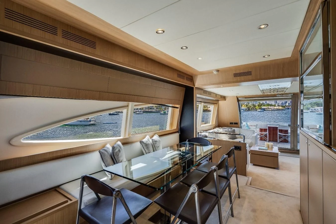 a room with a large window and a table with chairs and a large window aboard NAMEDROPPER Yacht for Sale