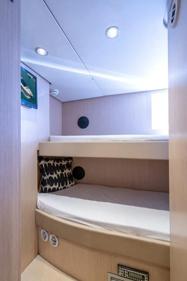 a room with a bed and a television on the wall aboard NAMEDROPPER Yacht for Sale
