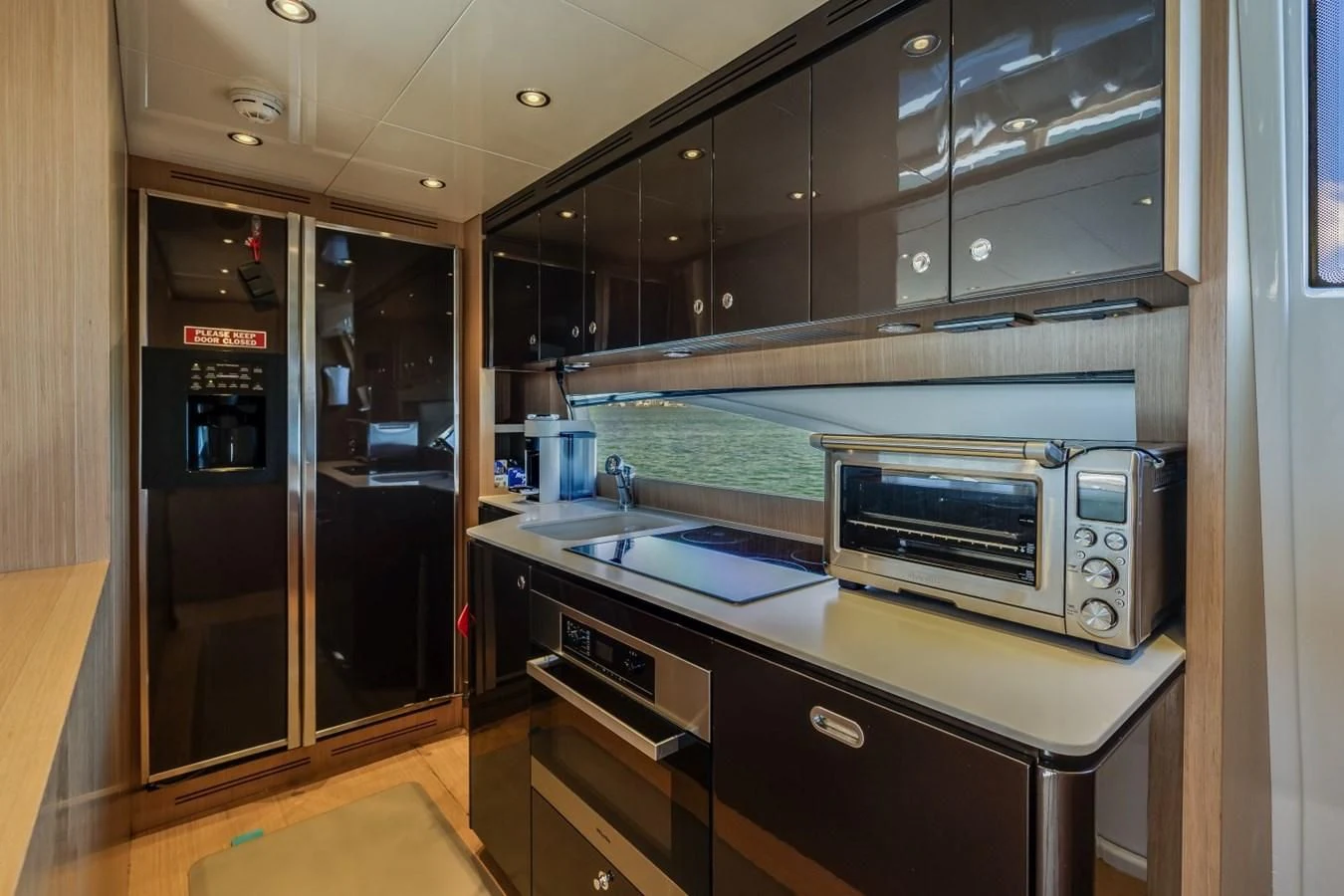 a kitchen with black cabinets aboard NAMEDROPPER Yacht for Sale