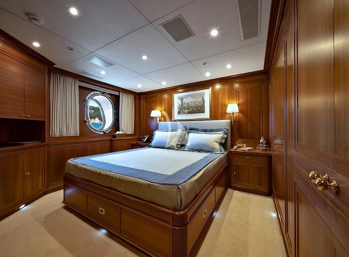 a bedroom with a bed and a mirror aboard JASALI II Yacht for Charter
