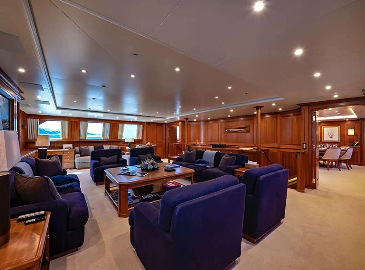 a living room with a large wood cabinet and a table aboard JASALI II Yacht for Charter