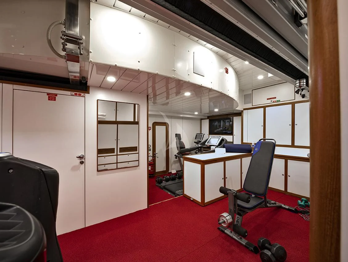 a room with a red carpet and a desk with a chair and a red carpet aboard JASALI II Yacht for Charter