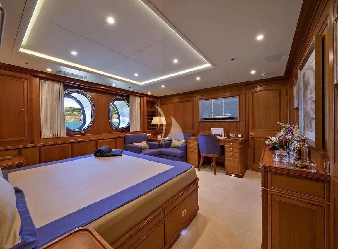 a bedroom with a blue bed aboard JASALI II Yacht for Charter