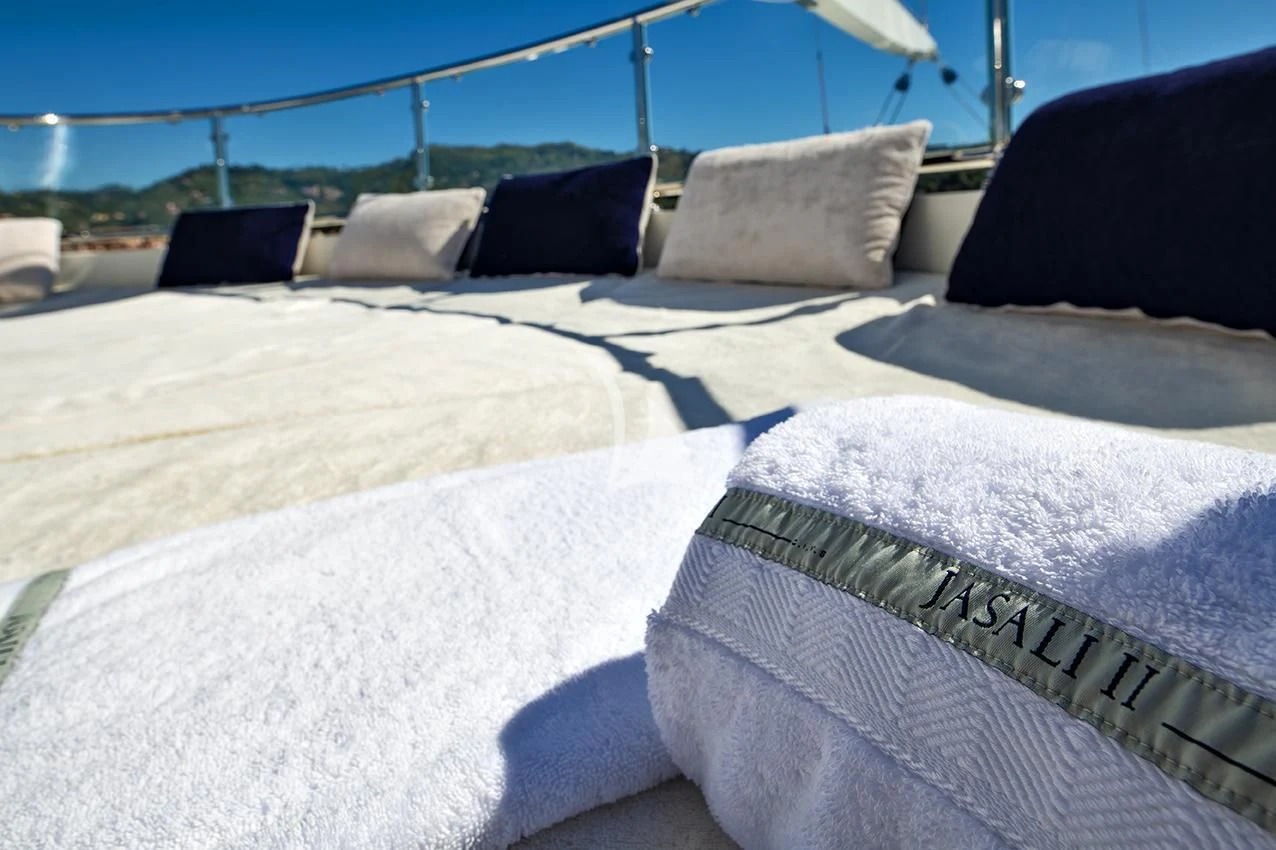 a bed with white sheets aboard JASALI II Yacht for Charter