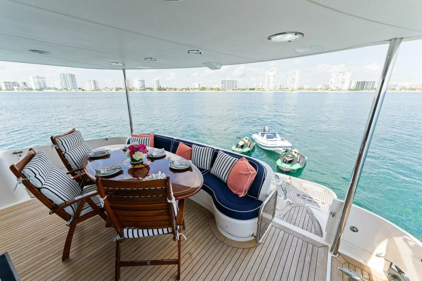 a table set for a meal on a deck overlooking a large body of water aboard CORAGGIO Yacht for Sale